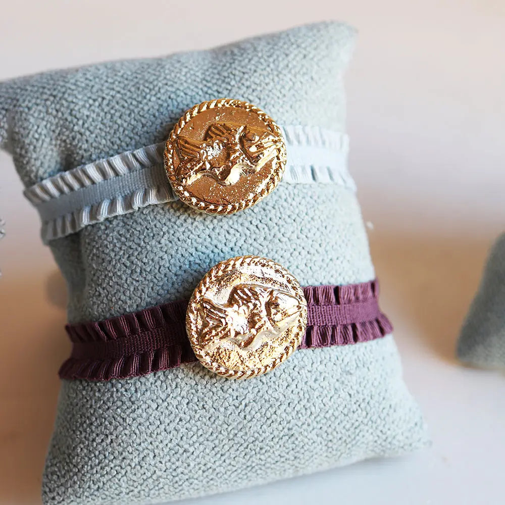 Pulseras de tela en azul claro y burdeos con botón dorado de diseño clásico. Perfectas para un estilo elegante.