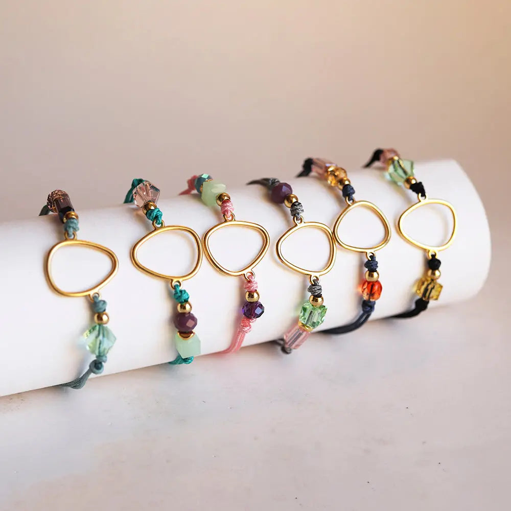 Pulseras de colores pastel con cuentas de vidrio y soporte dorado en forma de triángulo, estilo bohemio.