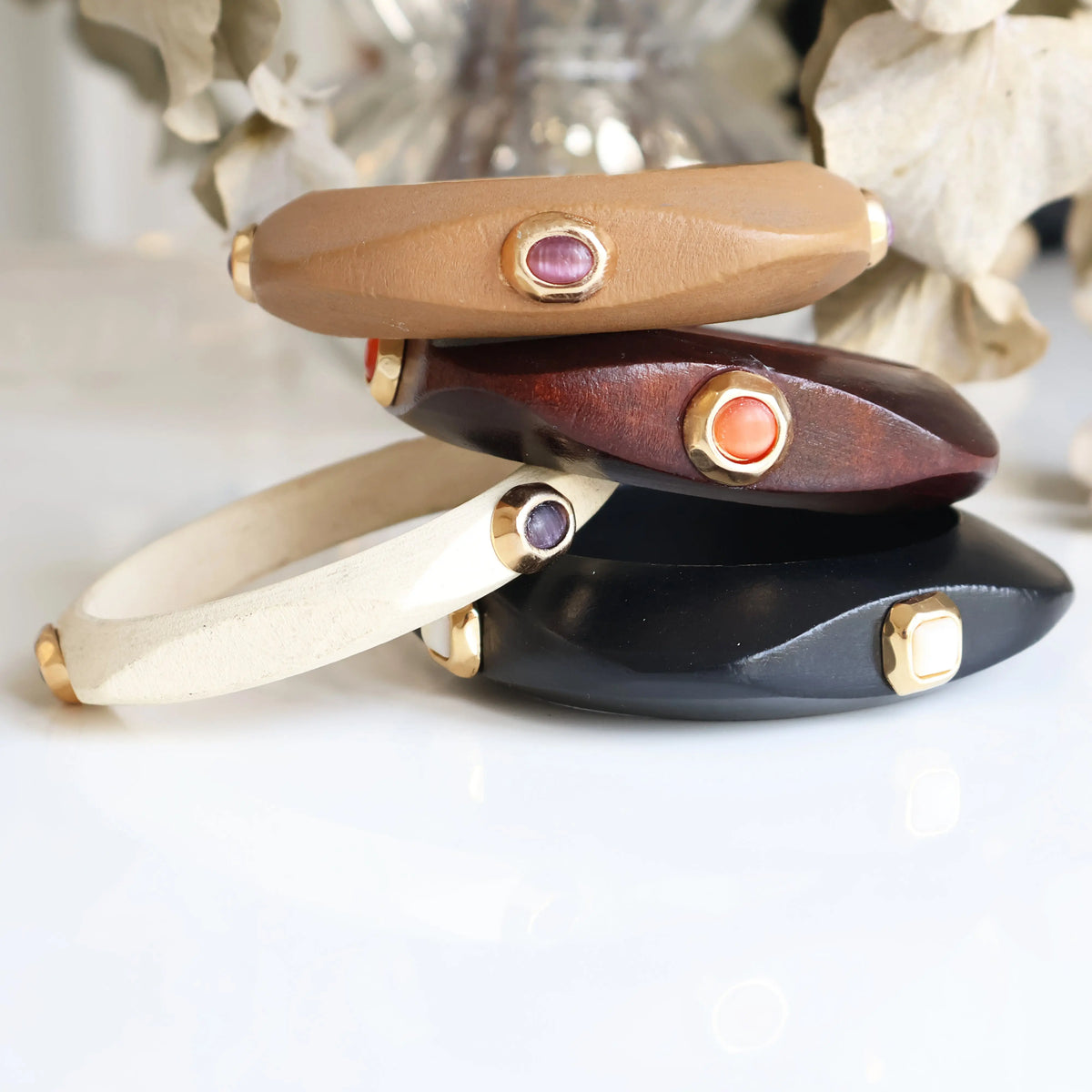 Pulseras de cuero en tonos marrón, negro, crema y vino, con gemas decorativas y detalles dorados.
