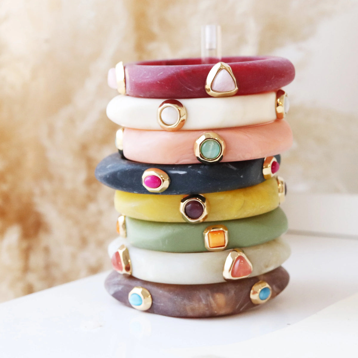 Pulseras de resina en tonos variados con detalles dorados, estilo bohemio y contemporáneo.