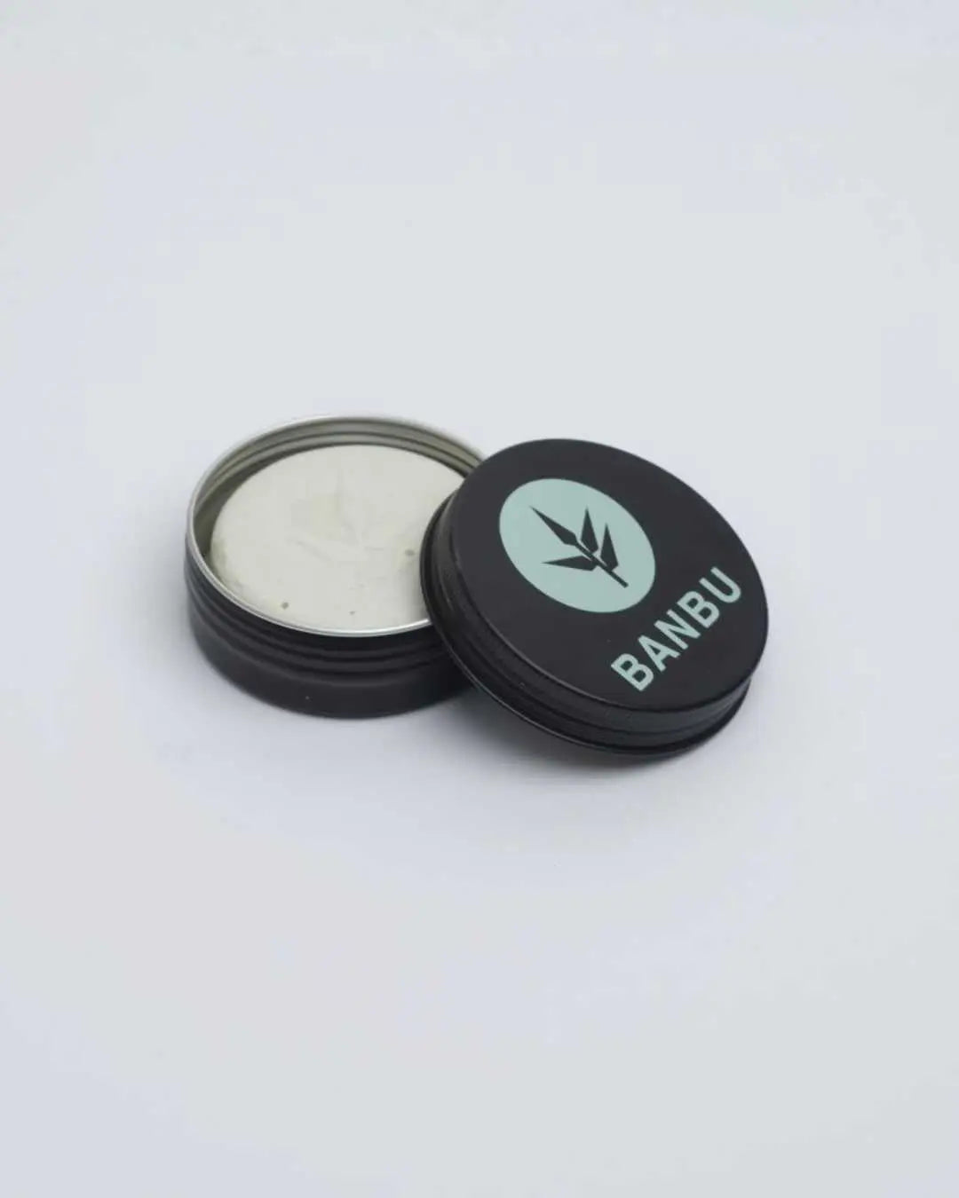 Refill de desodorante en crema Banbu en lata de aluminio negra abierta con producto cremoso claro y logo de hoja.