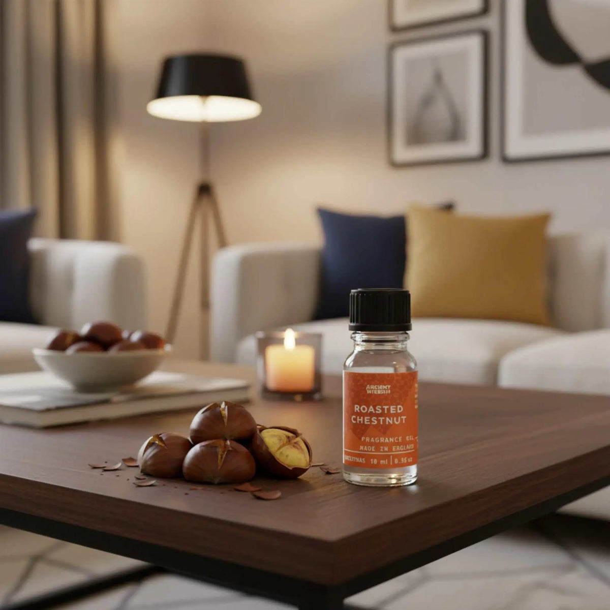 Frasco de aceite de 10 ml con etiqueta naranja de castañas asadas, junto a castañas reales sobre una mesa de madera.