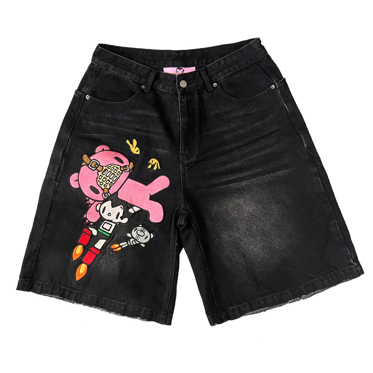 Black denim shorts featuring Gloomy Bear and Astro Boy embroidered patches on the left leg, isolated on white.