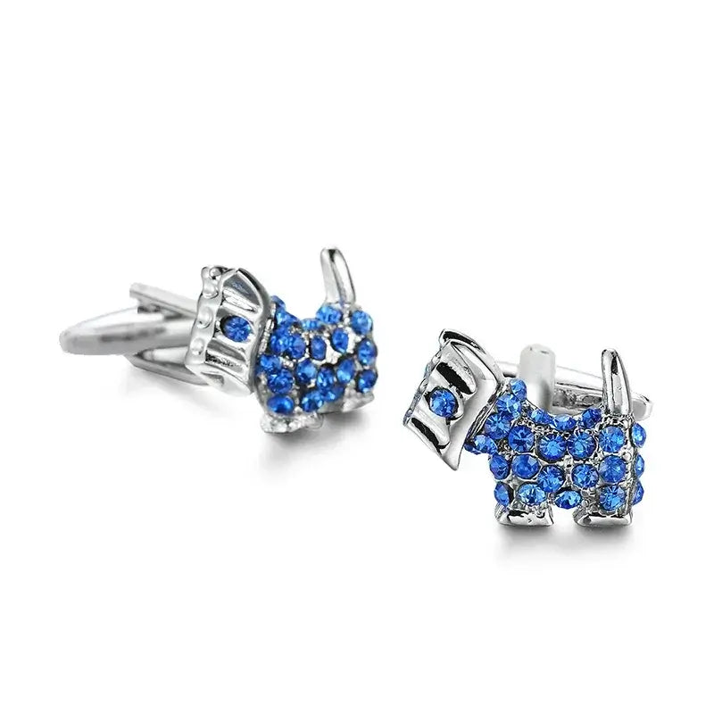 Gemelos plateados con forma de perro terrier, decorados con pequeños cristales brillantes de color azul intenso.