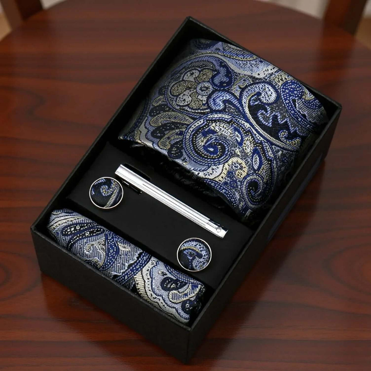 Set de regalo con corbata y pañuelo azul y platino con estampado paisley, gemelos a juego y pasador de corbata metal.