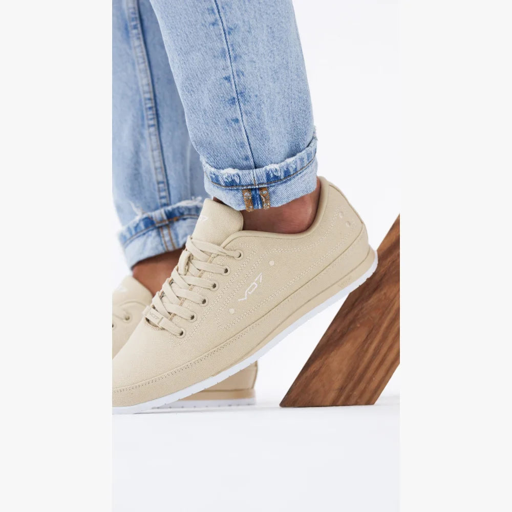 Sneakers VO7 Yacht 10 en toile beige avec semelle blanche, portées avec un jean clair, design sobre et élégant.