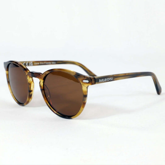 Gafas de sol redondas con montura de acetato efecto carey naranja brillante y lentes marrones sobre fondo blanco.