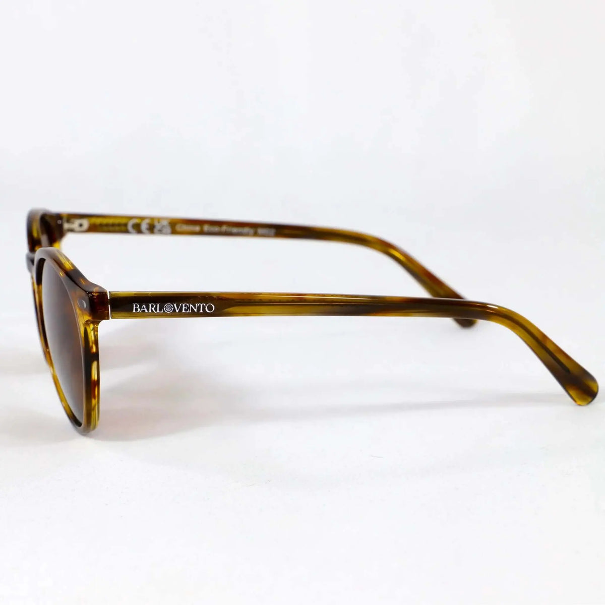 Gafas de sol redondas con montura de acetato efecto carey naranja cristal y lentes marrones sobre fondo blanco.