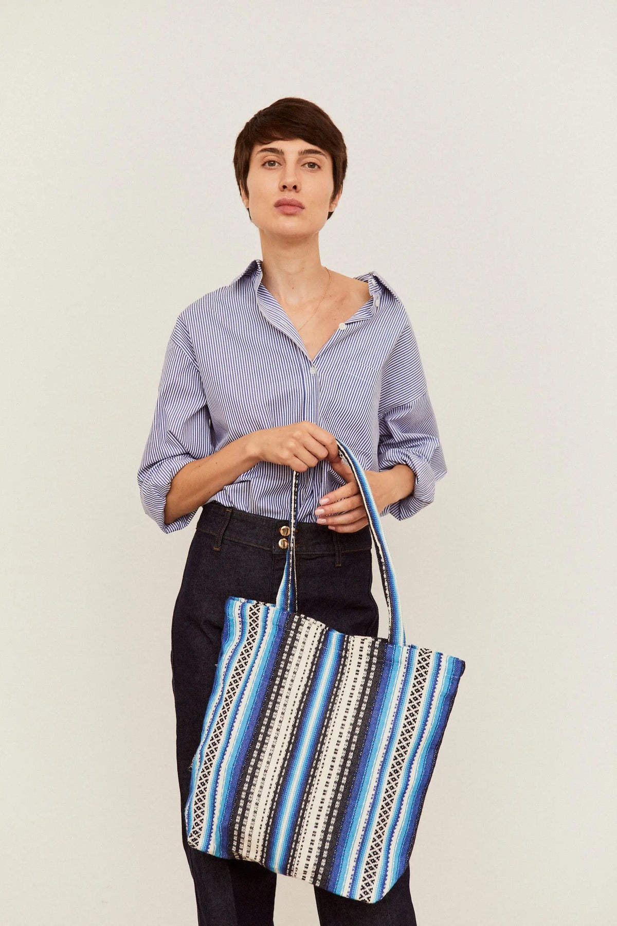 Tote bag de tela con estampado de rayas geométricas en tonos azules y blancos, estilo artesanal alpujarreño.