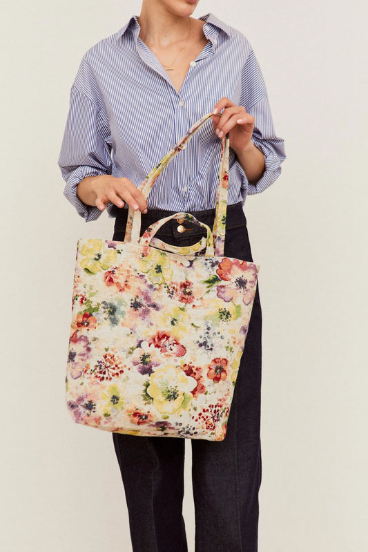 Tote bag de tela jacquard con estampado floral multicolor de amapolas, diseño estructurado y asas para colgar al hombro.