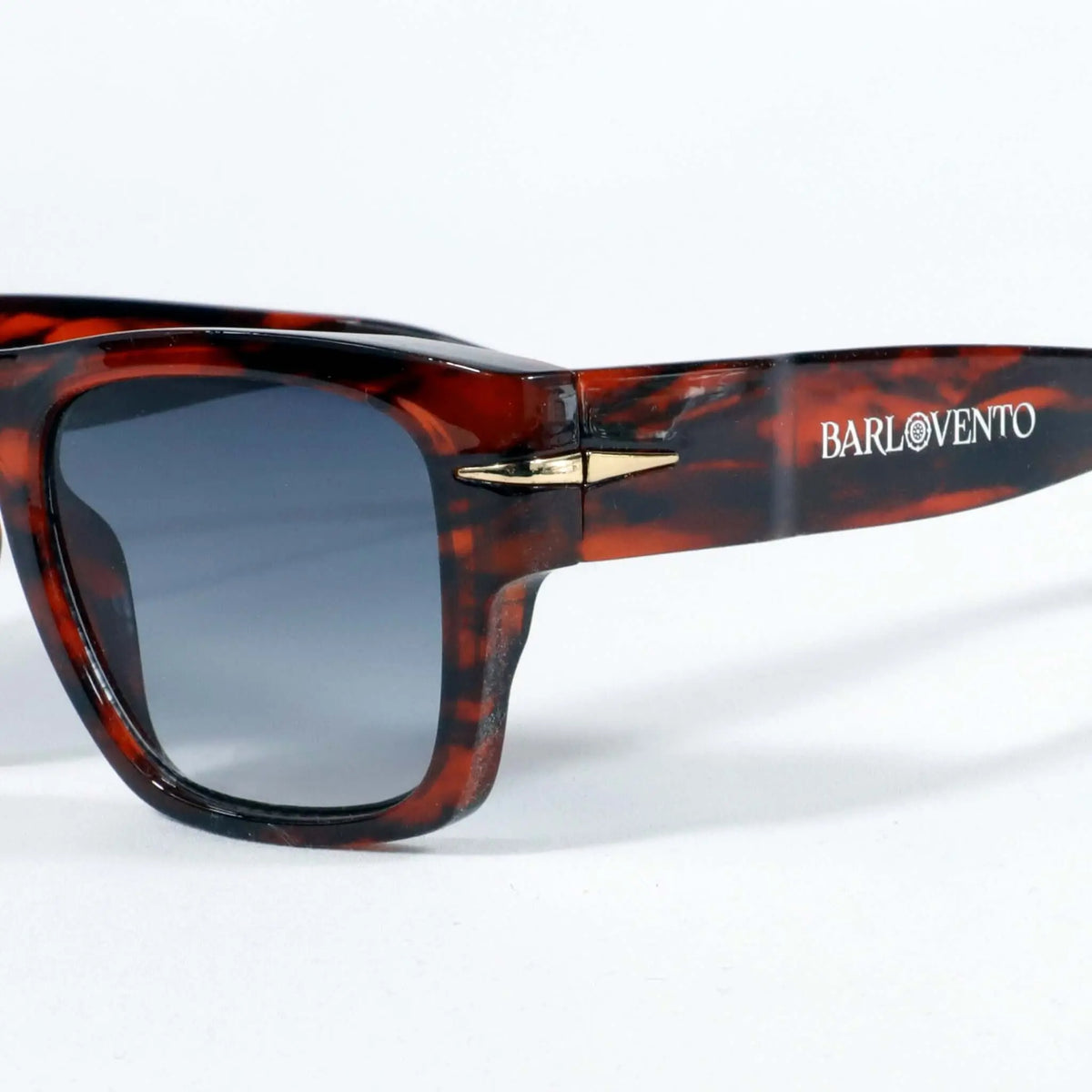Gafas de sol de carey con montura clásica, acabado brillante y lentes azules con protección UV400 sobre fondo blanco.