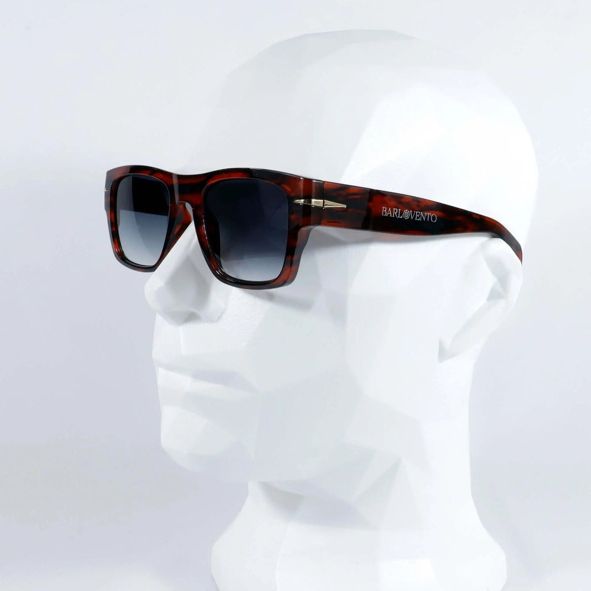Gafas de sol de carey con montura cuadrada y lentes degradadas azules, sobre maniquí blanco, estilo clásico y elegante.
