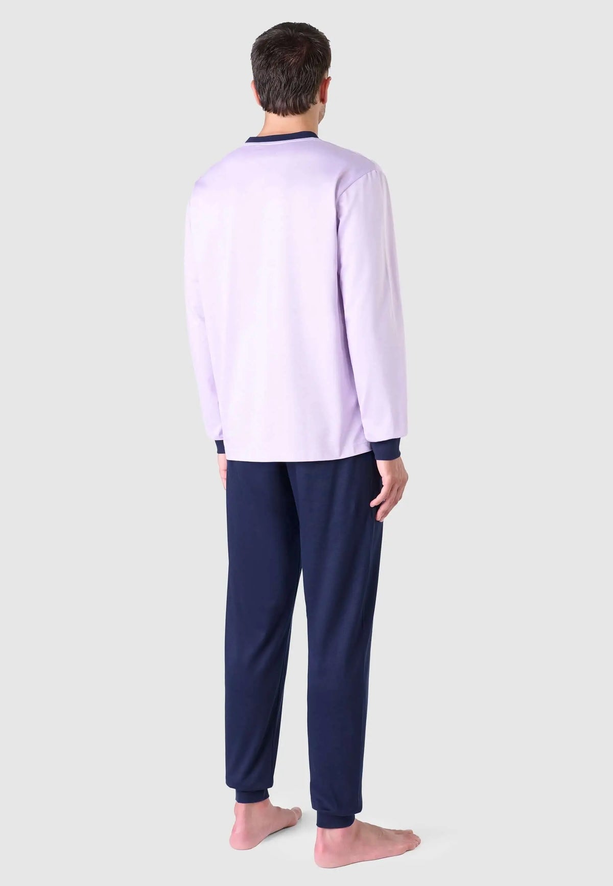 Pijama largo hombre El Búho Nocturno: camiseta rosa lisa de manga larga con puños azul marino y pantalón azul marino.