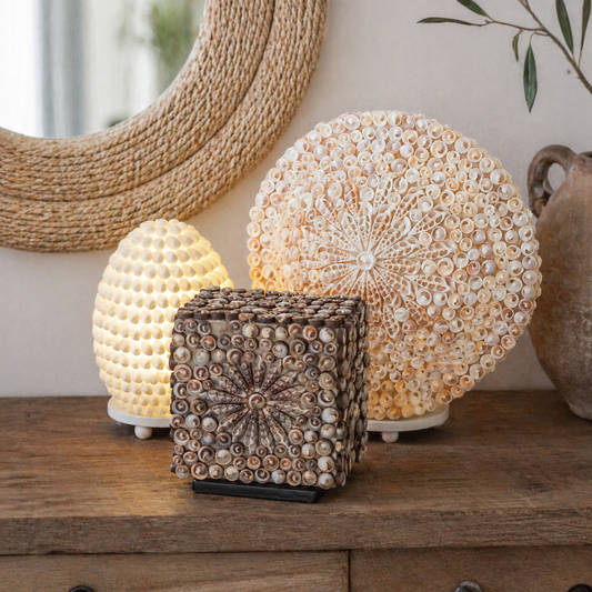 Lámparas y decoración con conchas naturales sobre madera — estilo mediterráneo moderno primavera 2026