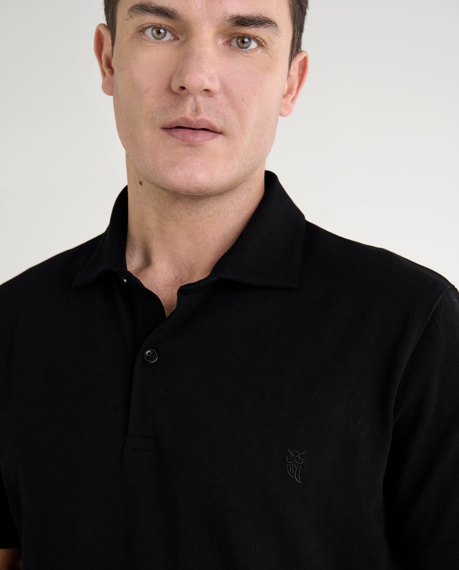 Polo negro de algodón para hombre con logotipo bordado, estilo clásico y cómodo.