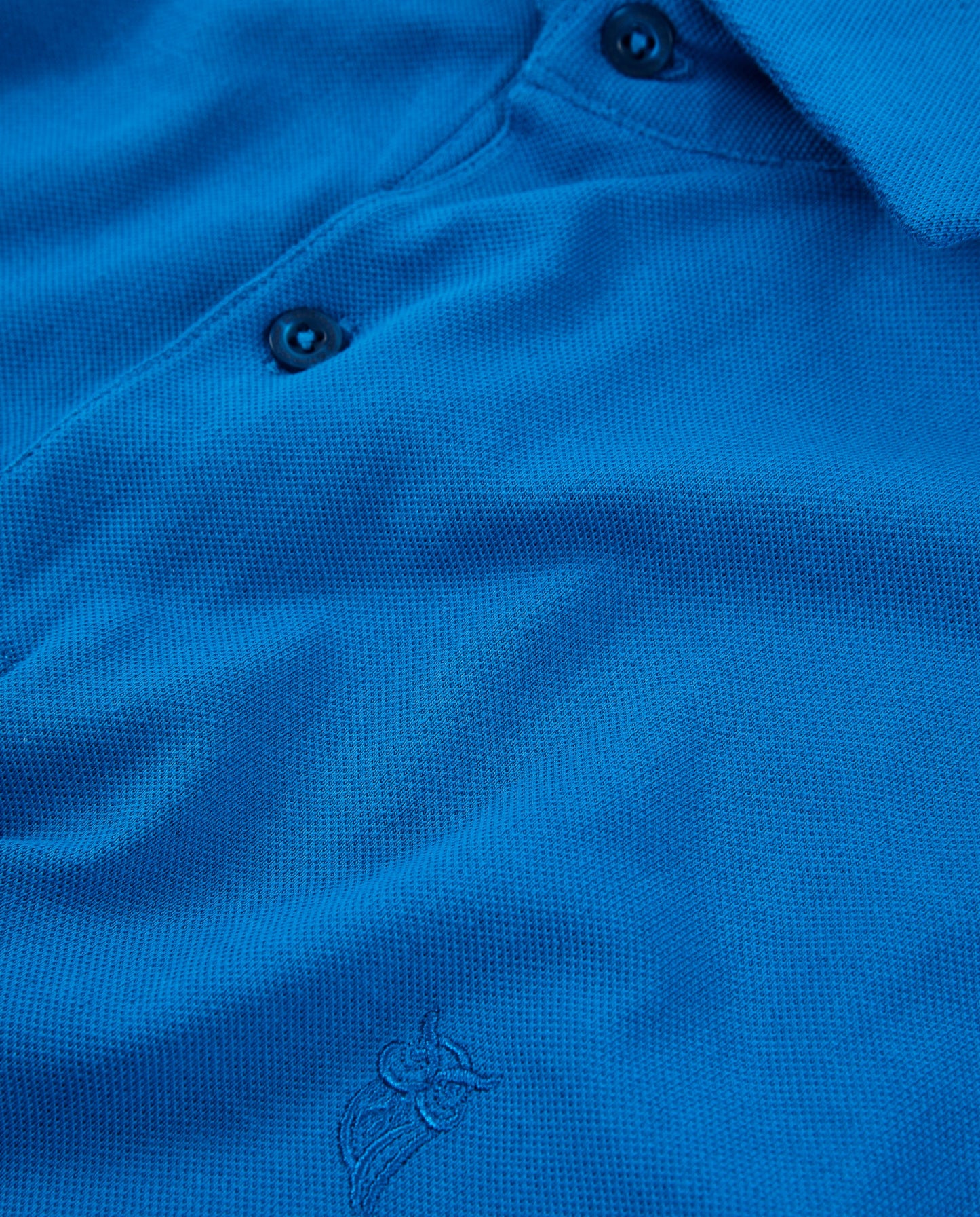 Polo azul vibrante de algodón, diseño clásico con cuello y bordado en el pecho. Ideal para un look casual.