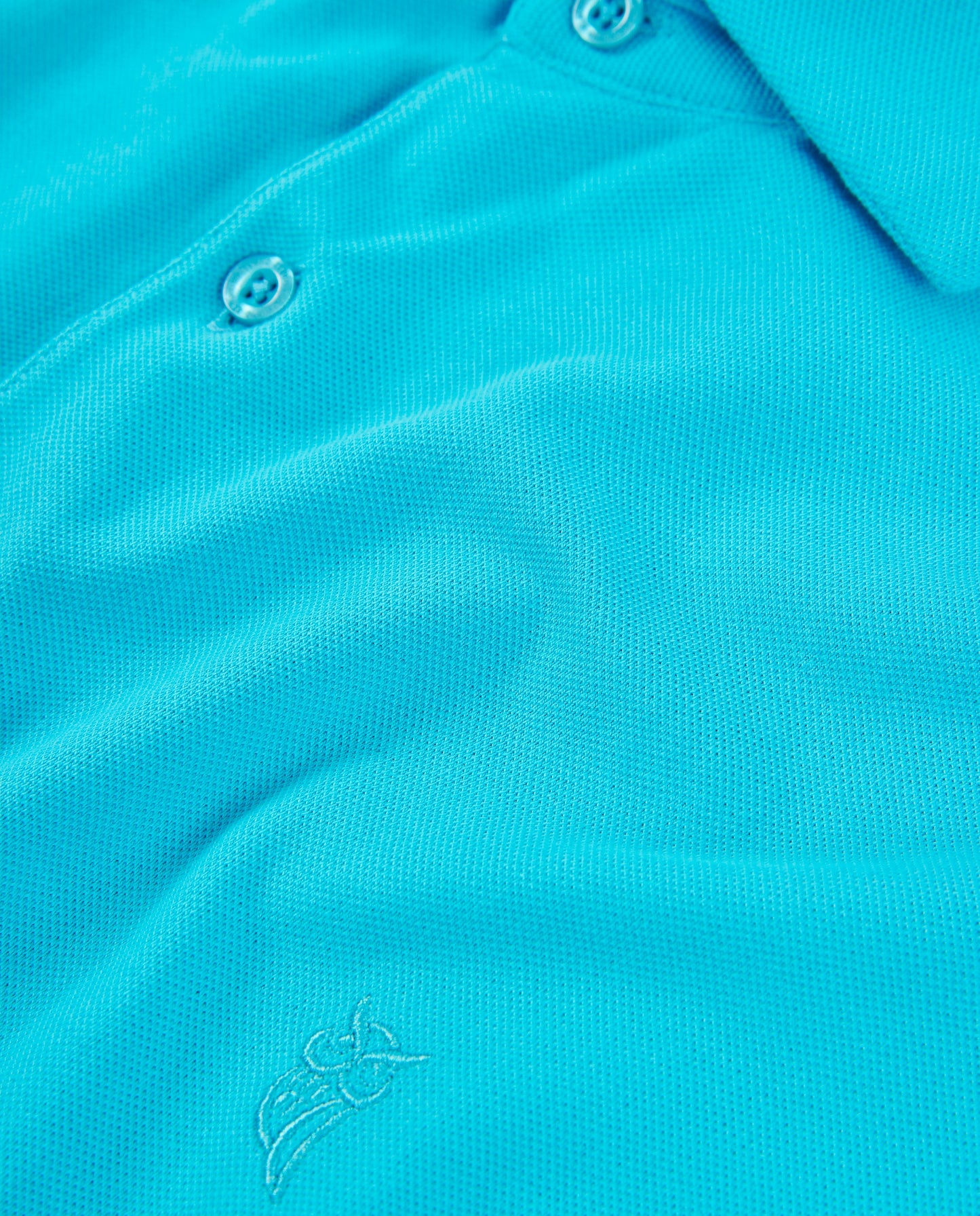 Polo de color aqua, material de malla, diseño moderno, con bordado de logo en el pecho.