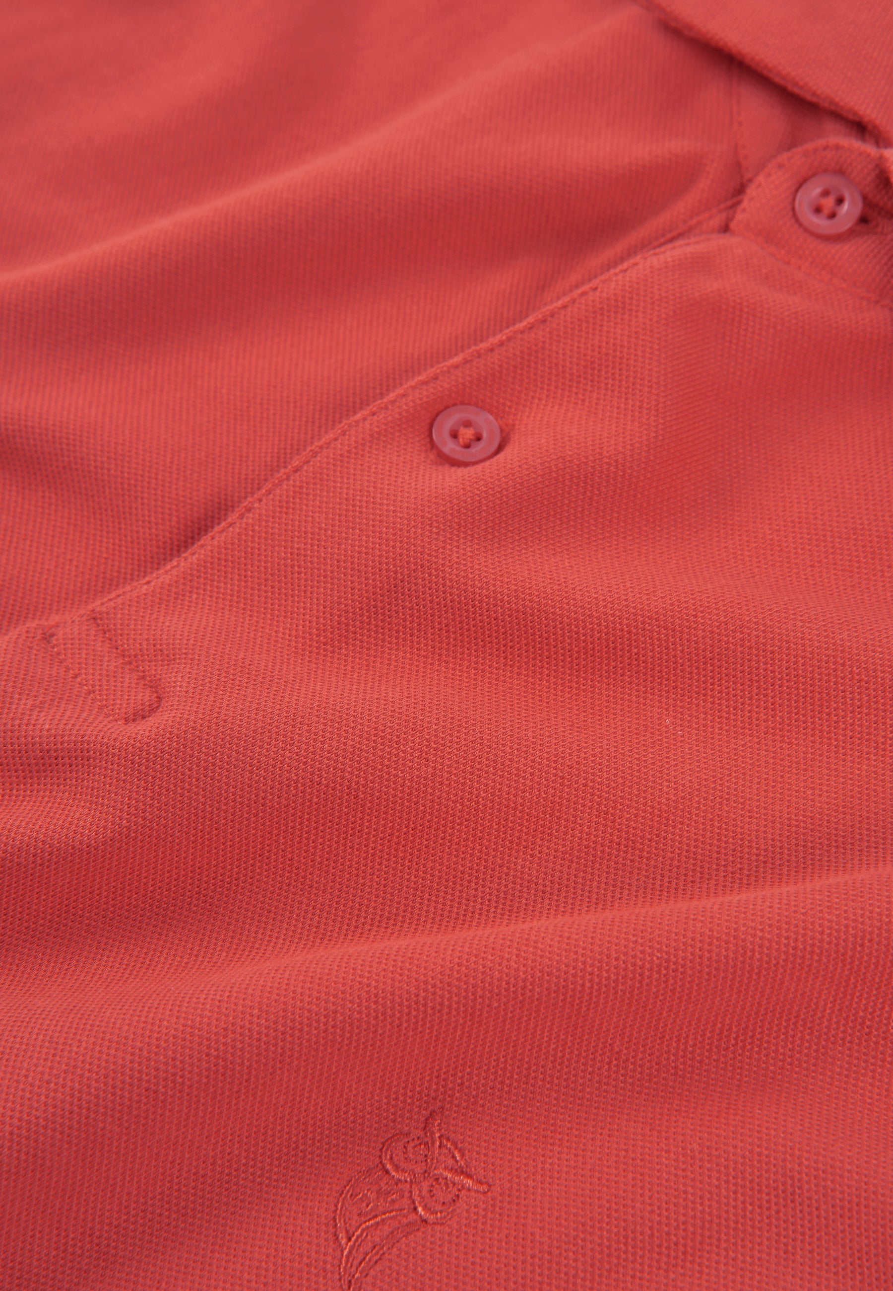 Polo de algodón pique en color coral con botones tonales y bordado en el pecho. Perfecto para un look casual.