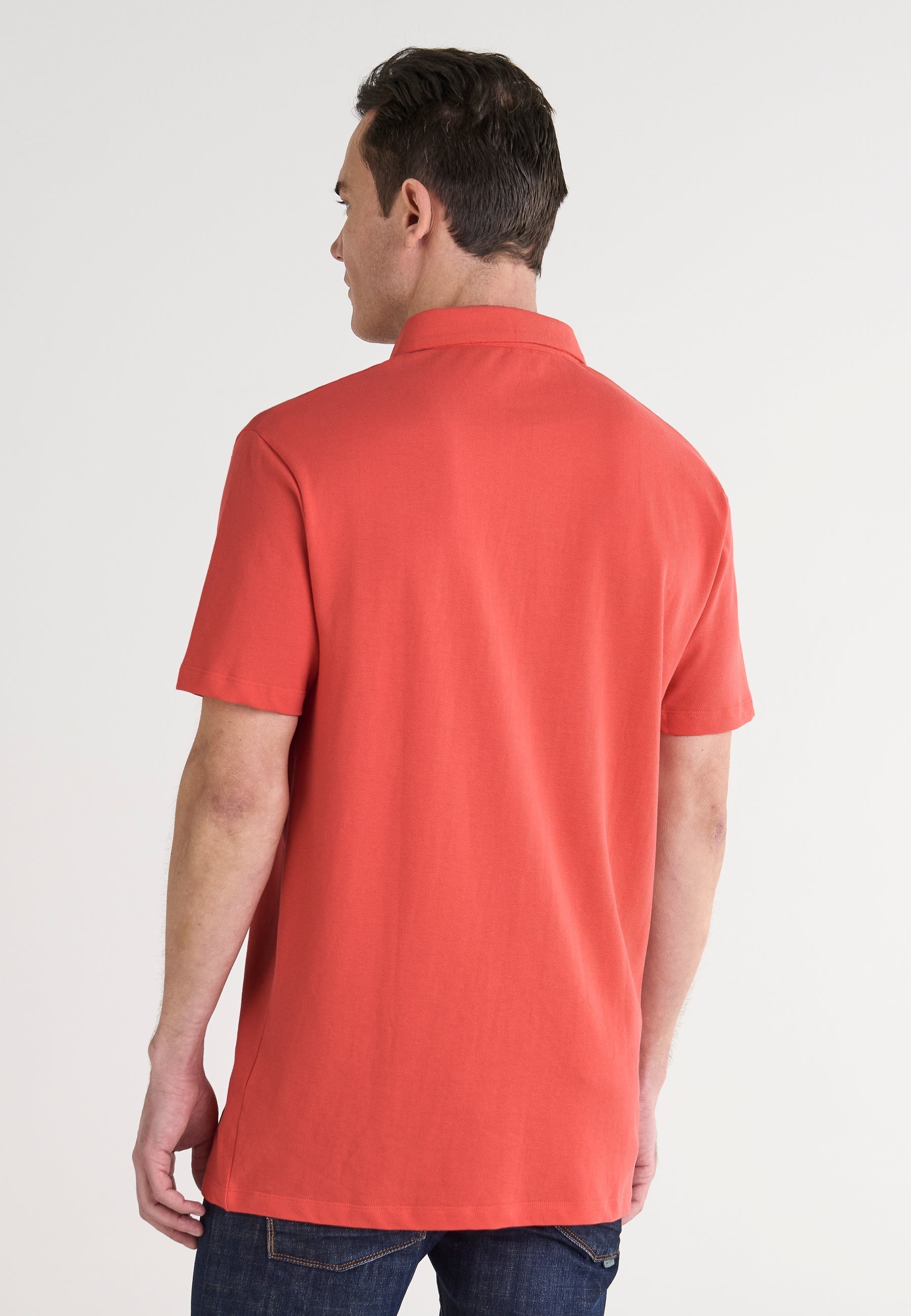 Camisa polo de hombre en color coral, de algodón suave, estilo casual, con mangas cortas y corte moderno.