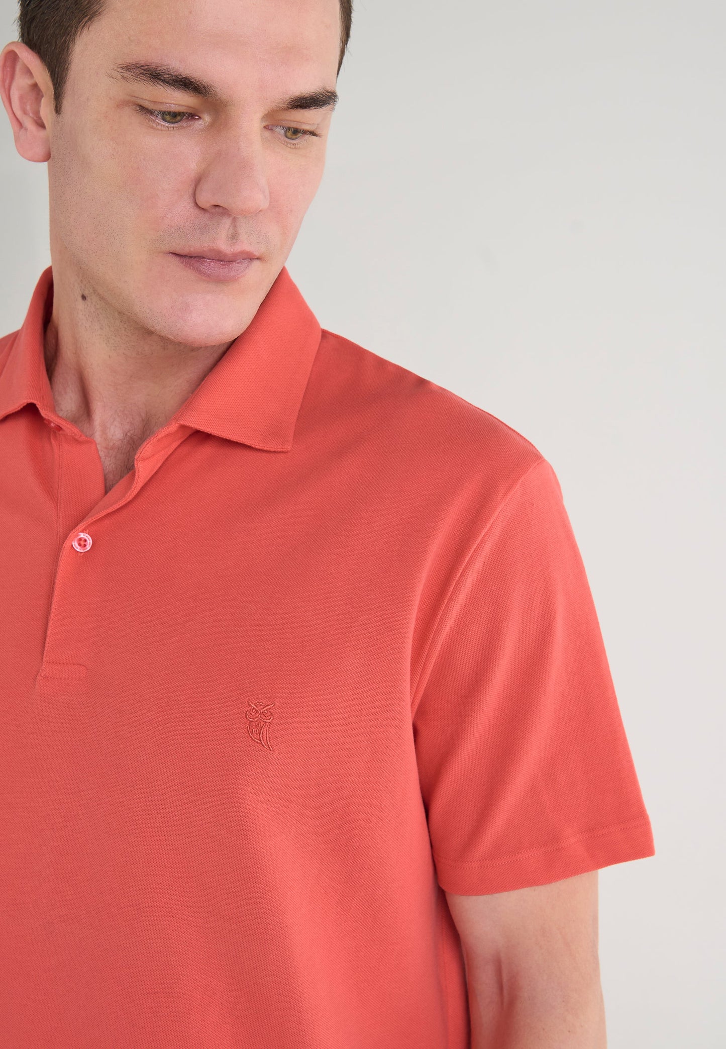 Polo de hombre en color coral, algodón suave, estilo clásico con botón y logo bordado.