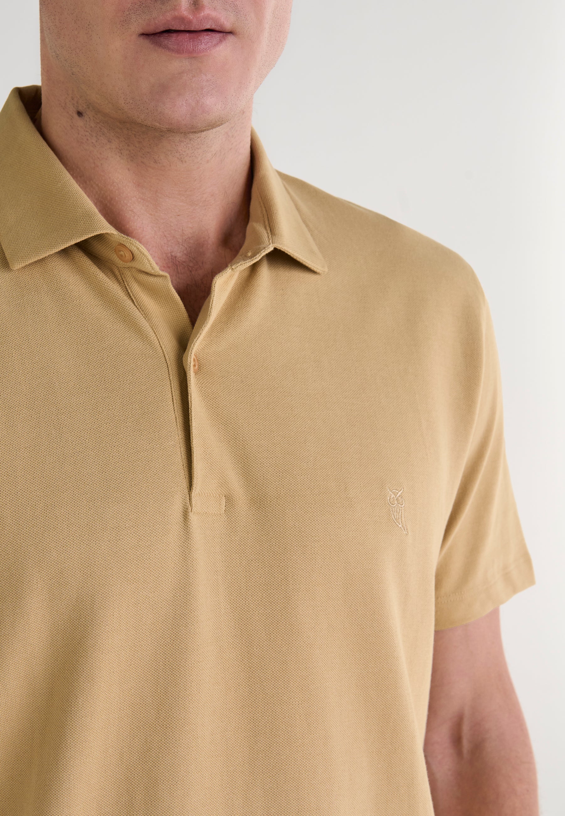 Polo de hombre color mostaza de algodón, con cuello clásico y logo bordado en el lado izquierdo del pecho.