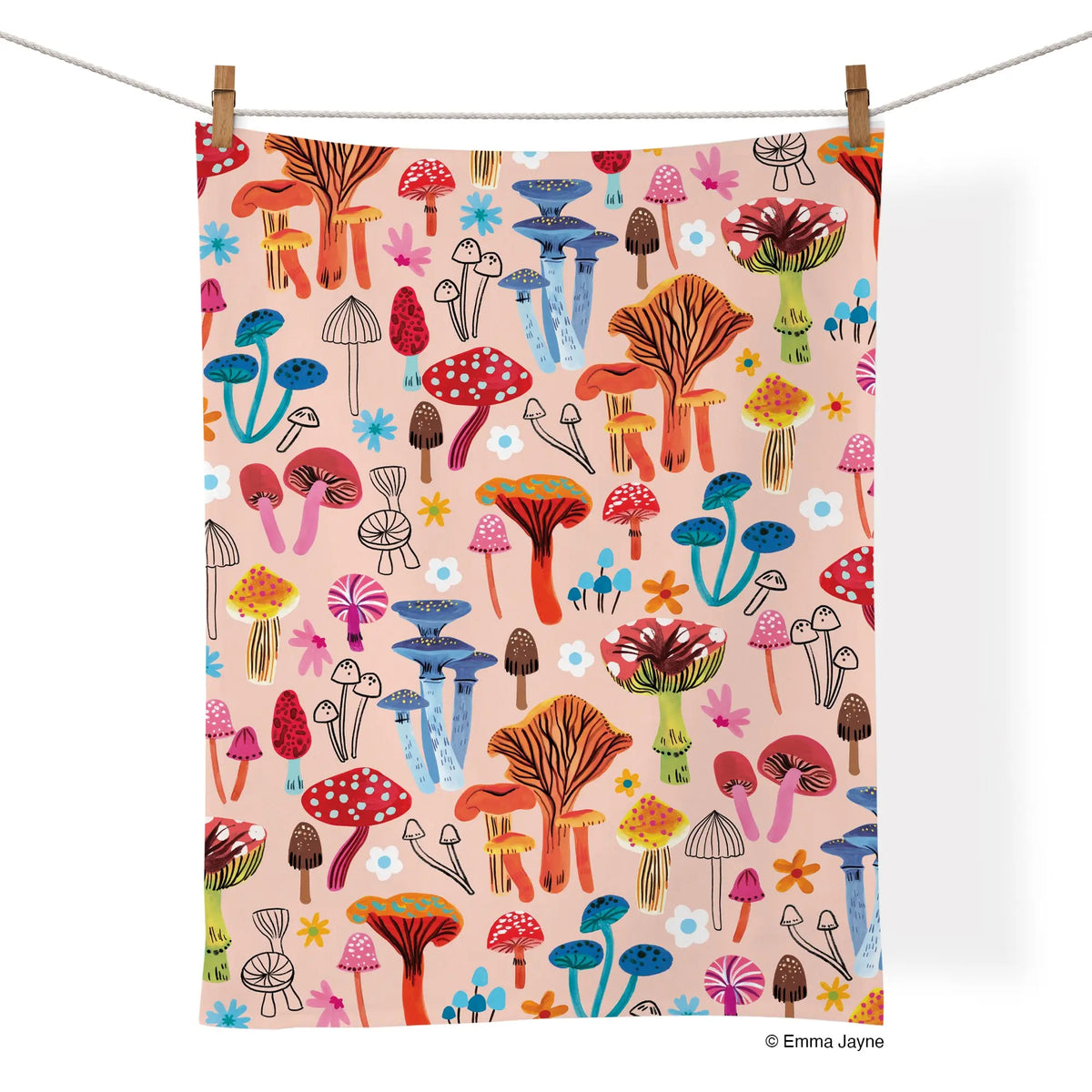 Cotton kitchen towel with a colorful mushroom and flower pattern on a light pink background, hanging on a clothesline.