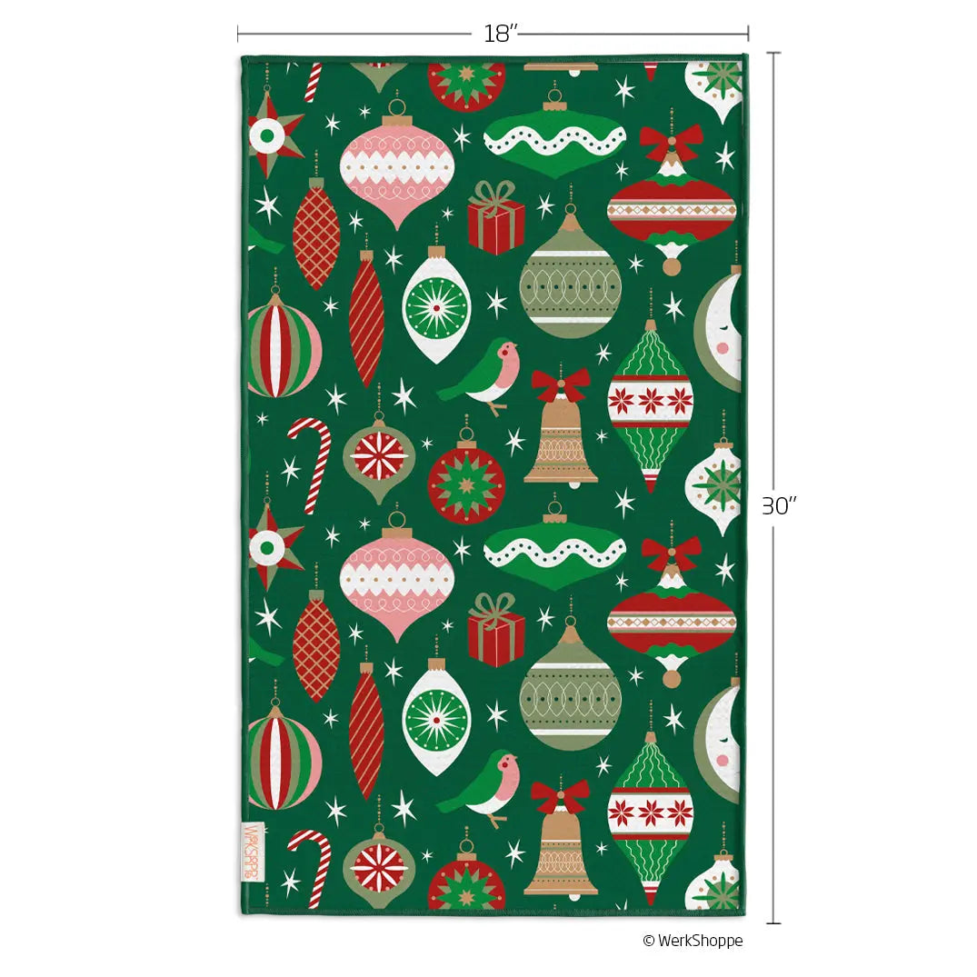 Microfiber towel in dark green with a festive pattern of Christmas ornaments, bows, candy canes, and birds. 18"x30".