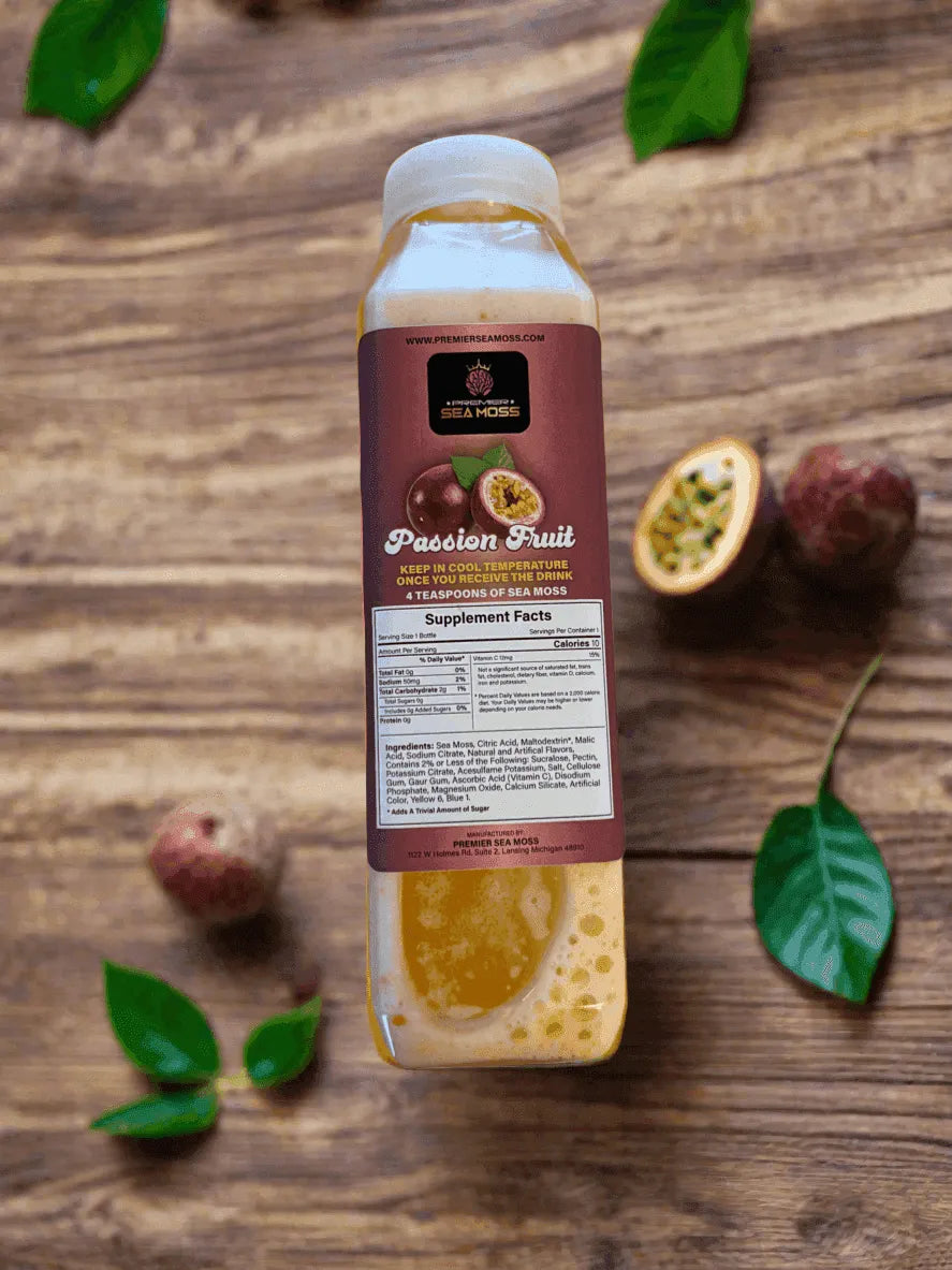 A 12 oz bottle of passion fruit sea moss lemonade on a rustic wood surface with fresh passion fruit and green leaves.