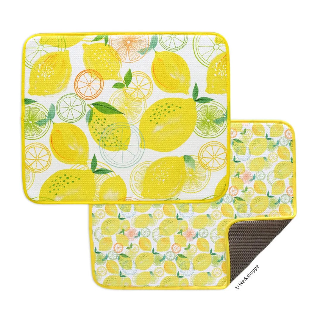 Two rectangular dish drying mats with a yellow, white, and orange lemon and citrus slice pattern and yellow trim.
