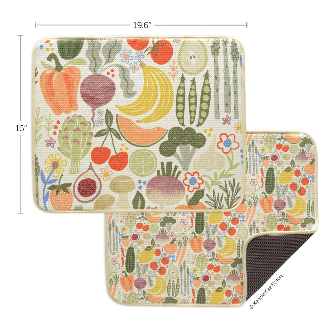 Two rectangular dish drying mats featuring colorful, patterned illustrations of fruits and vegetables on cream fabric.