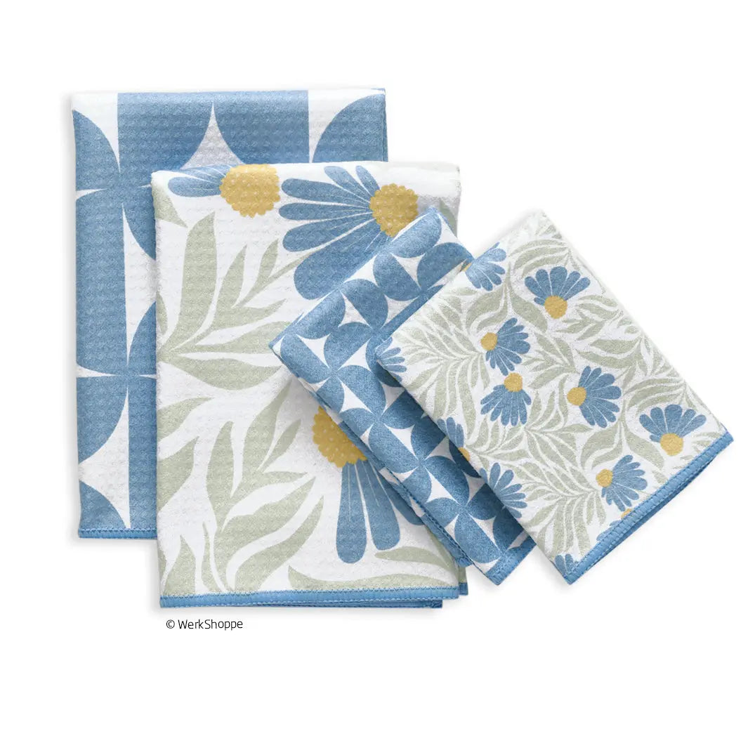 Three kitchen towels featuring blue and yellow coneflower floral patterns and geometric designs on white fabric.
