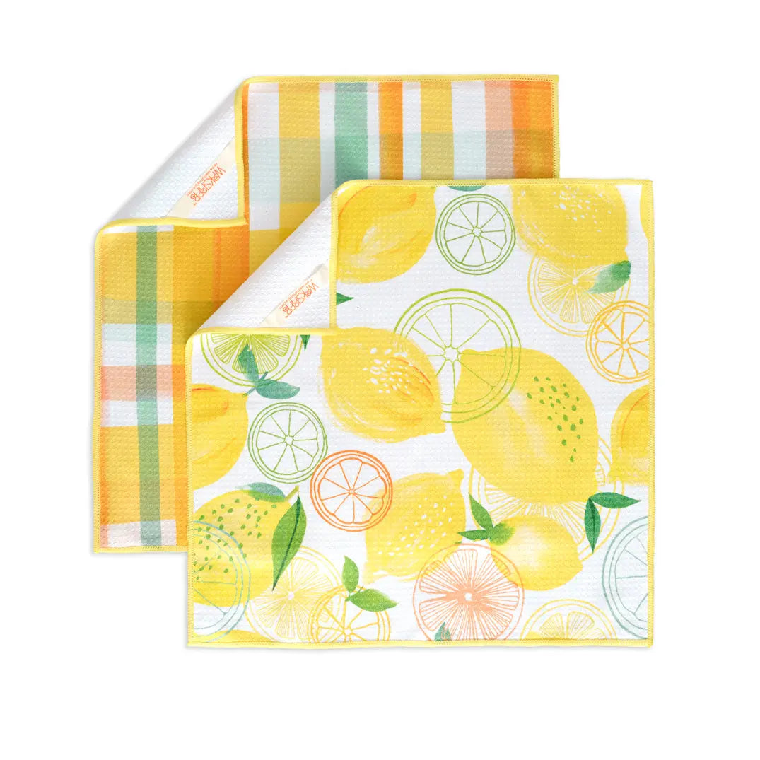 Set of two waffle-weave kitchen towels featuring a lemon pattern on one and a yellow-green plaid on the other.