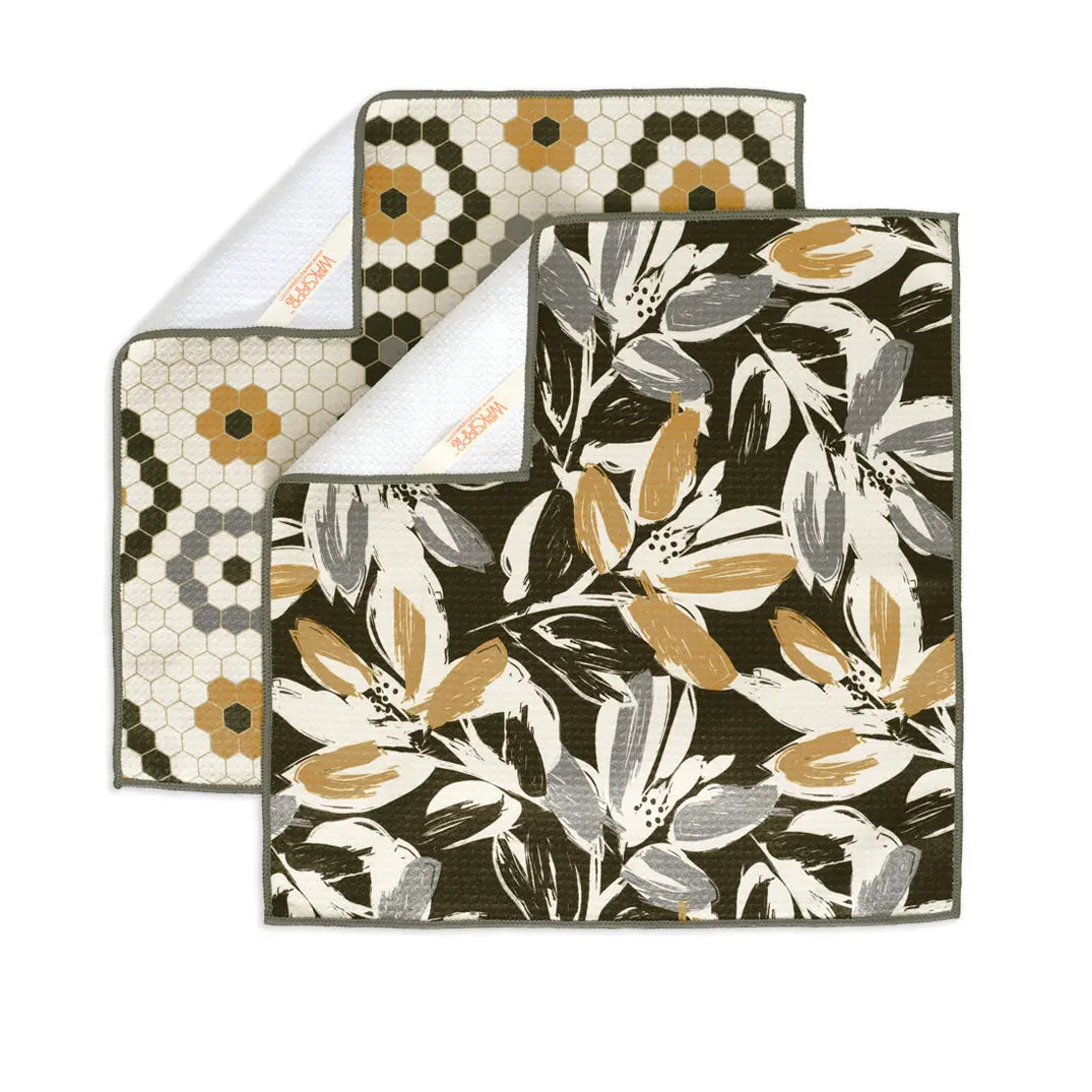 Two all-purpose towels: one with a gold and white hexagonal tile print, the other with a dark abstract floral pattern.