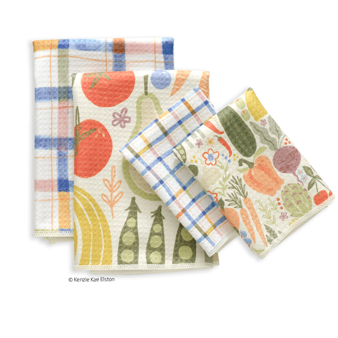 Set of four Farm Stand towels featuring vibrant, artistic prints of vegetables, fruits, and blue and yellow plaid.