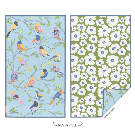 Reversible microfiber towel featuring a blue bird and branch pattern on one side and a white floral print on green.
