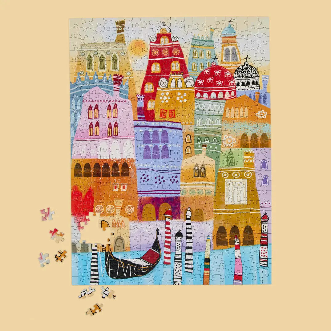 A 500-piece puzzle showing a whimsical, colorful illustration of Venice buildings, a gondola, and striped pilings.