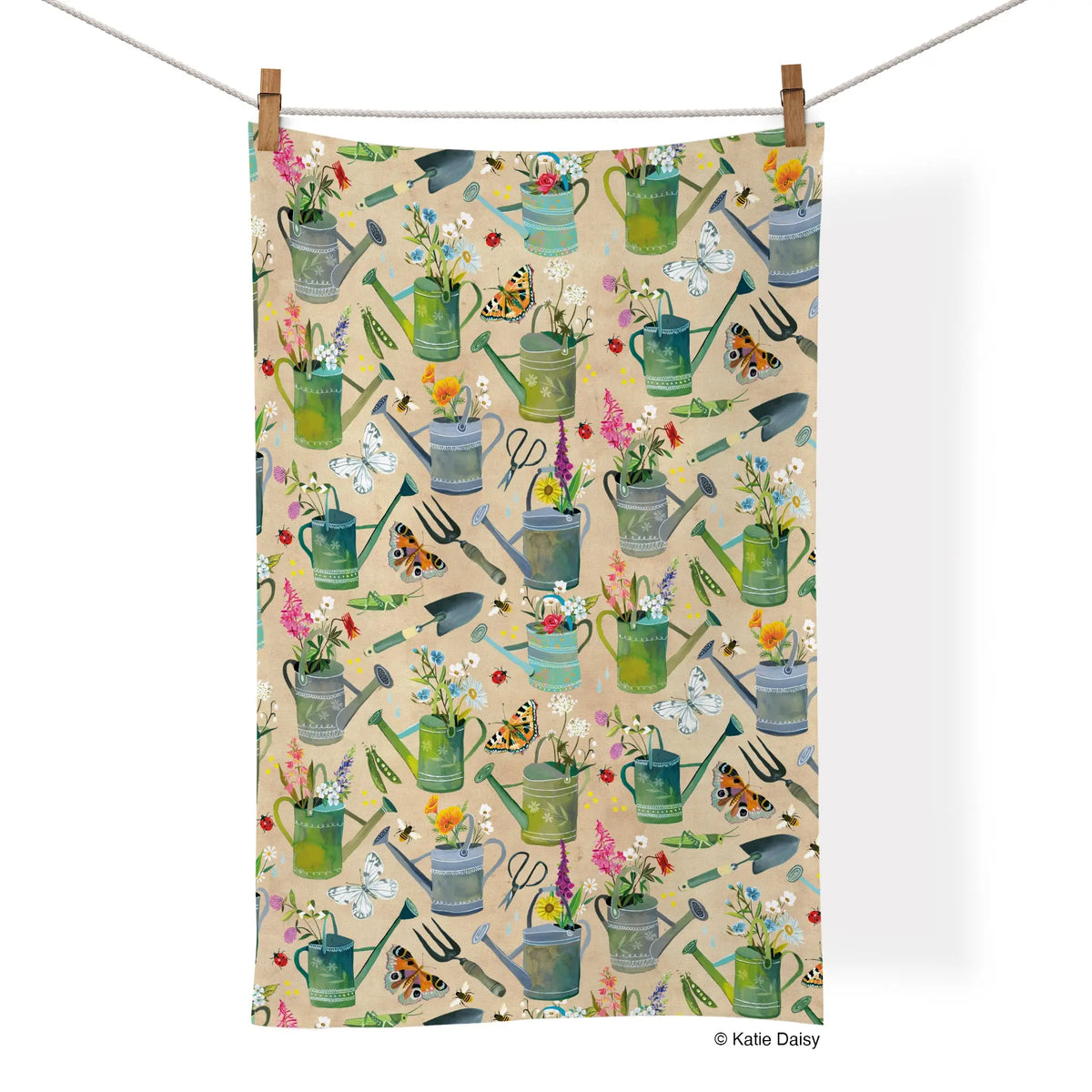 Cotton tea towel with a beige background featuring a repeating garden pattern of watering cans, flowers, and insects.