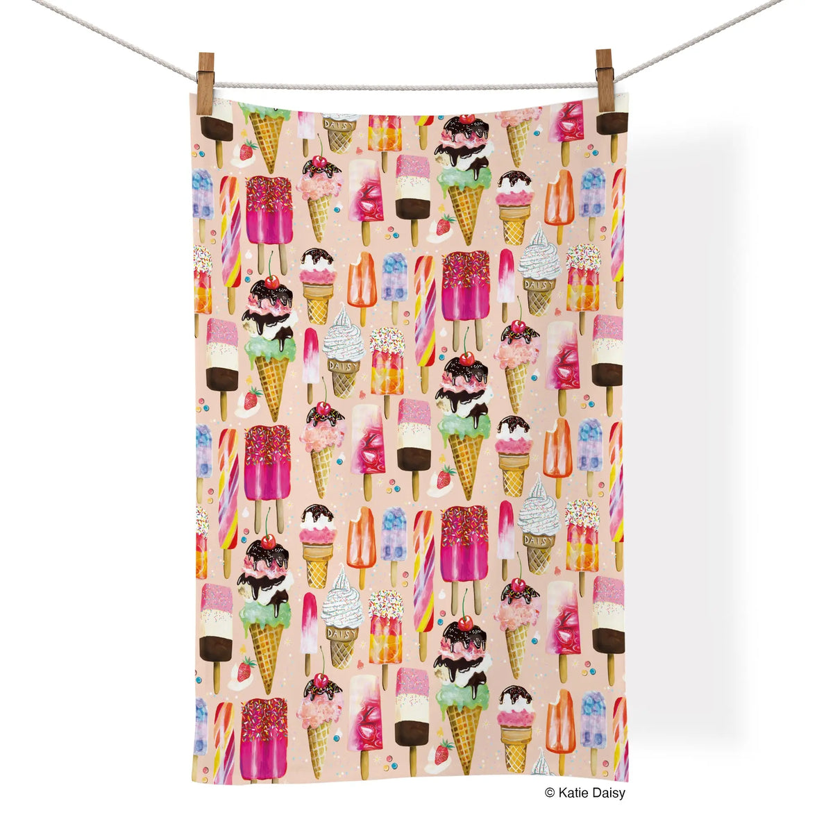 Cotton tea towel with a colorful, repeating pattern of various ice cream cones and popsicles on a soft pink background.