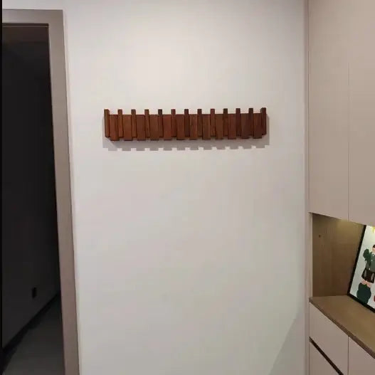 Perchero de pared Verona de madera natural, colgador plegable escandinavo en pared blanca.