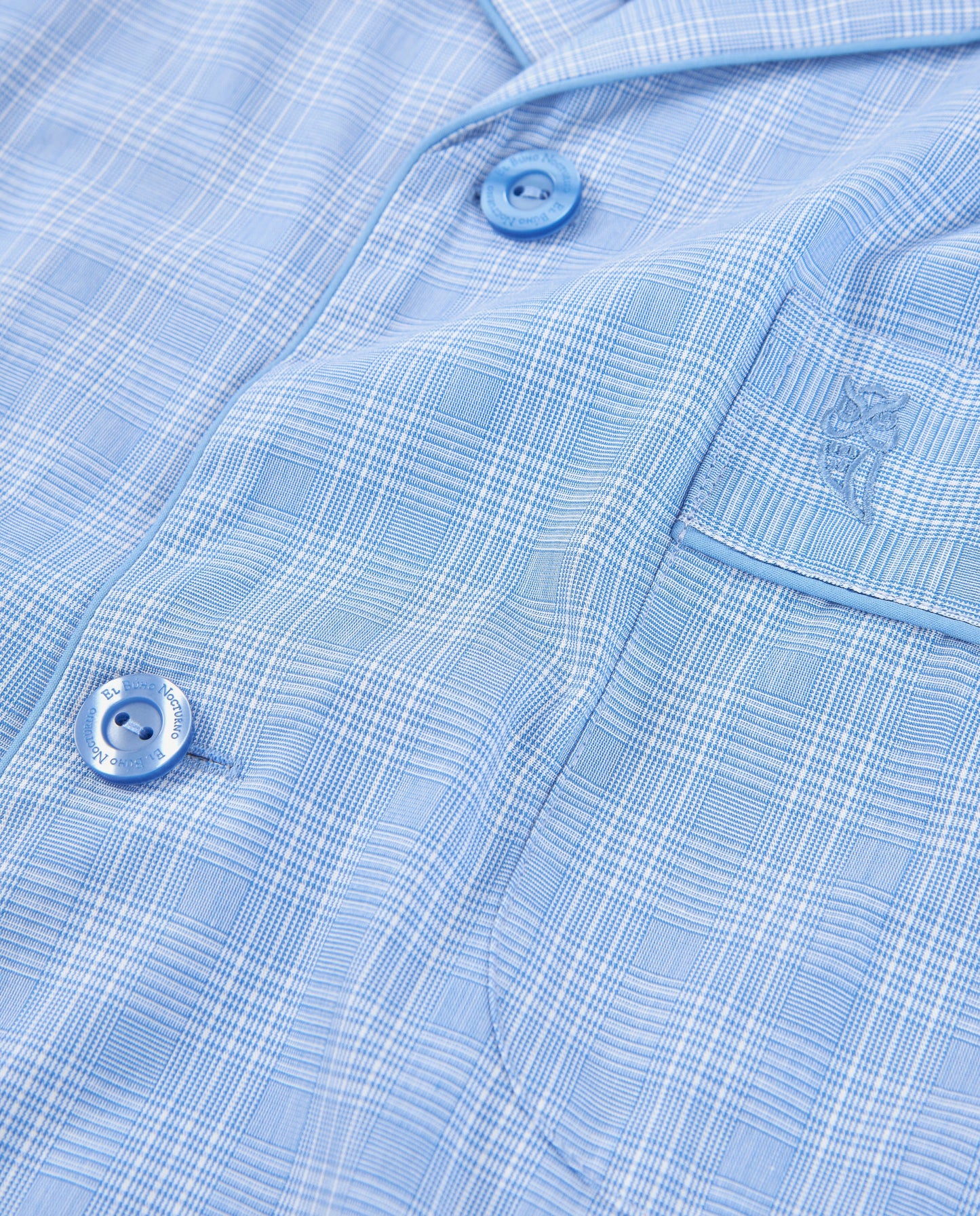 Camisa de hombre de cuadros en azul claro, algodón suave, estilo moderno con botones azules y bolsillo.