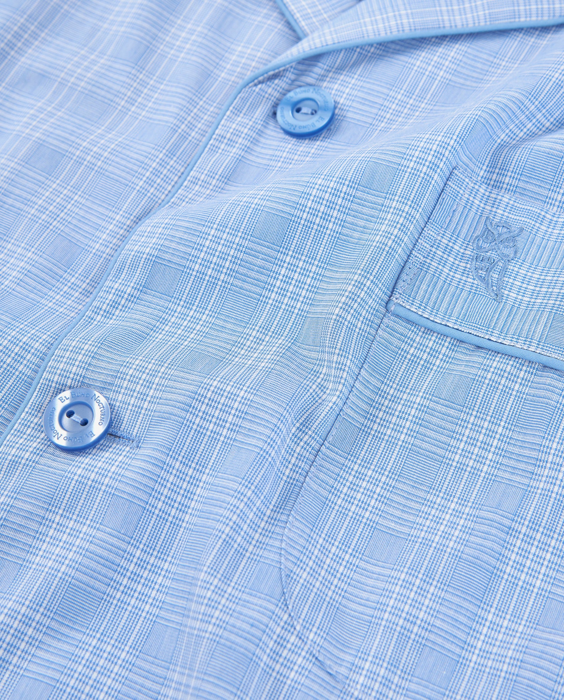 Camisa de hombre de cuadros en azul claro, algodón suave, estilo moderno con botones azules y bolsillo.