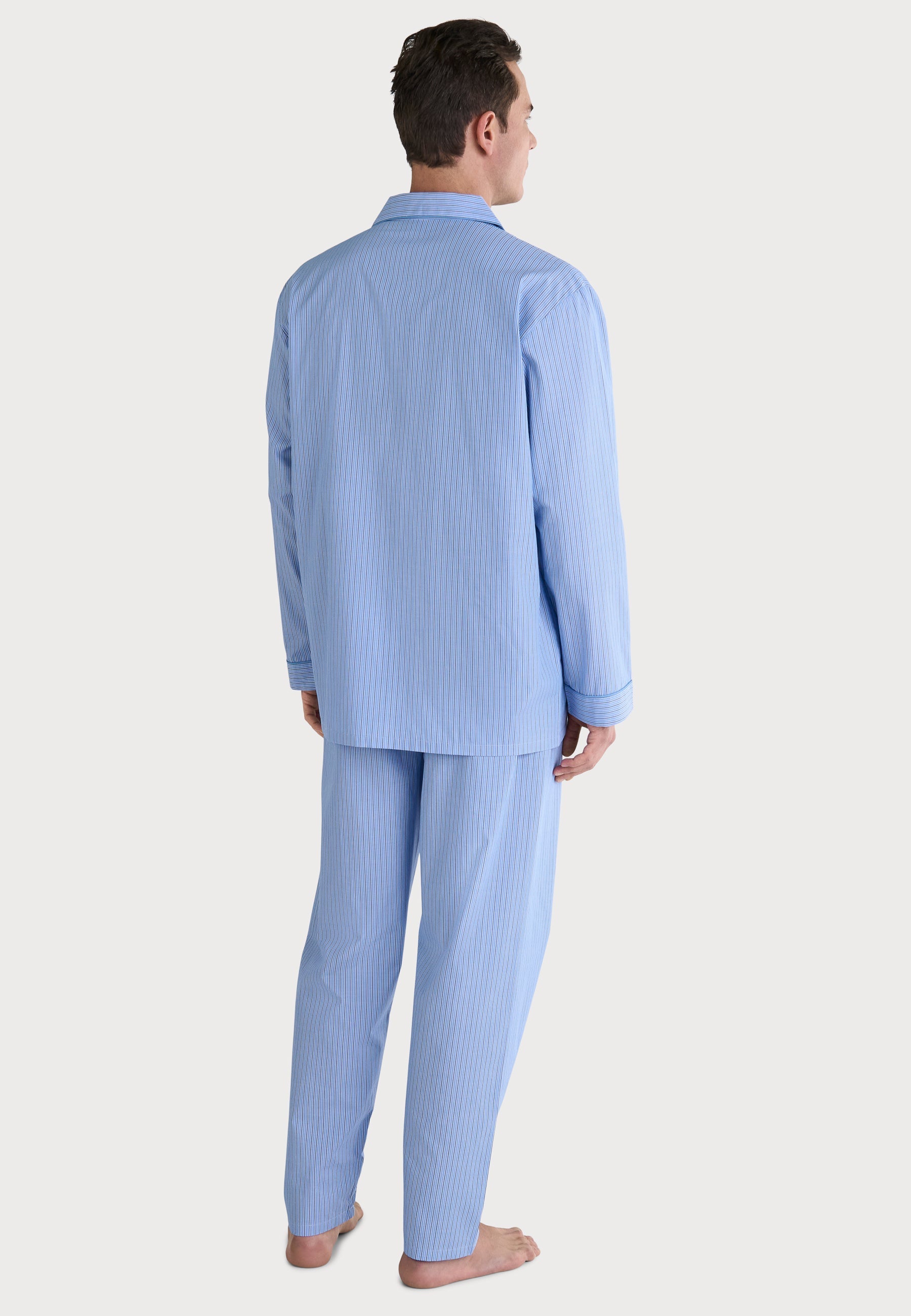 Pijama de hombre rayado azul claro, de algodón suave, estilo clásico con camisa de botones y pantalones cómodos.