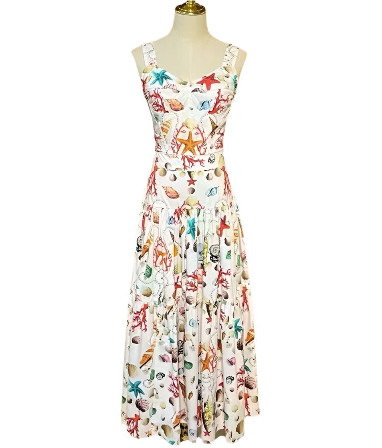 White cotton maxi dress with a colorful Mediterranean-inspired seashell and coral print, featuring a fitted bodice.
