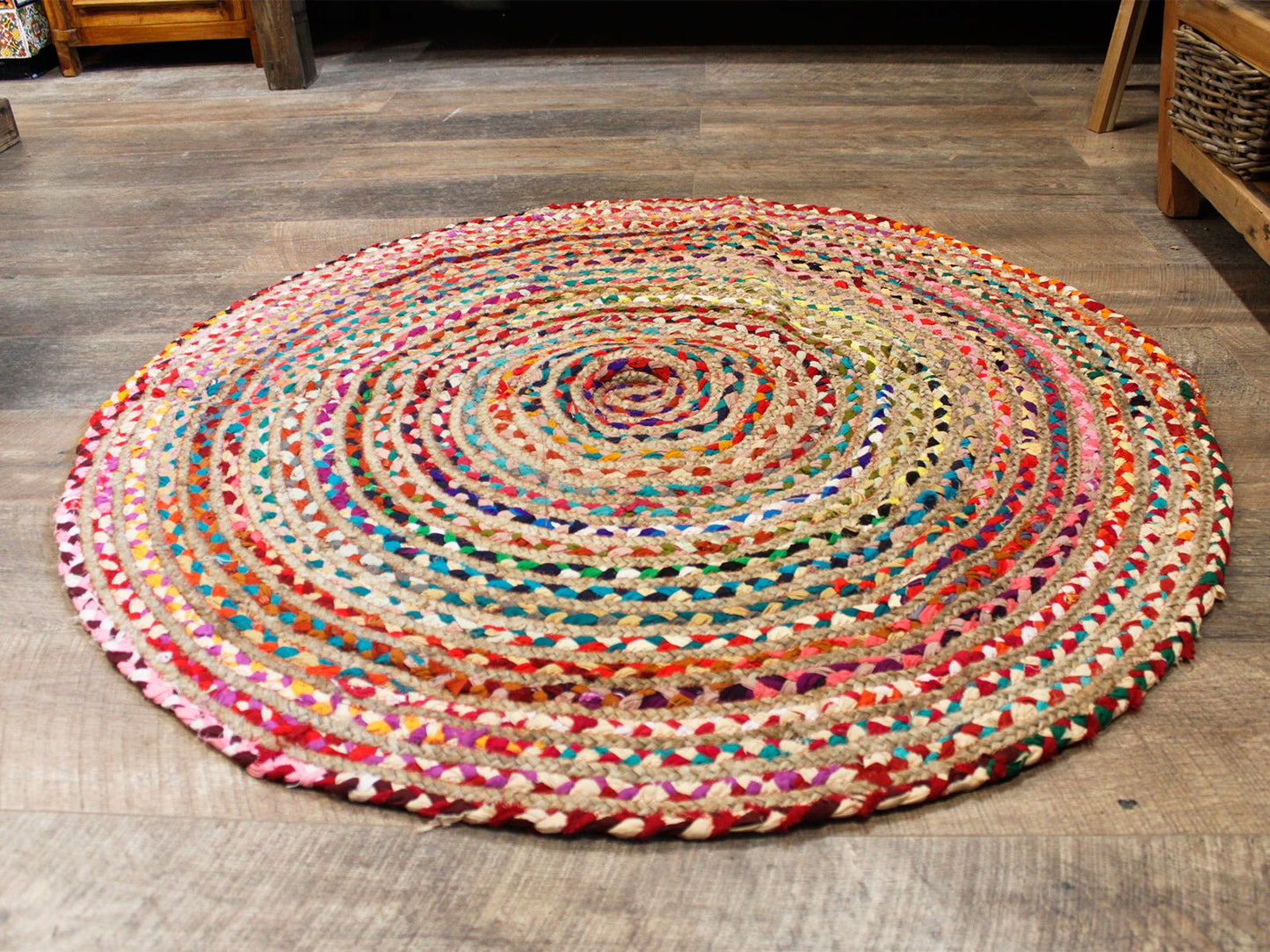 Colorful round braided area rug made of natural jute and cotton, featuring vibrant hues and a bohemian style.