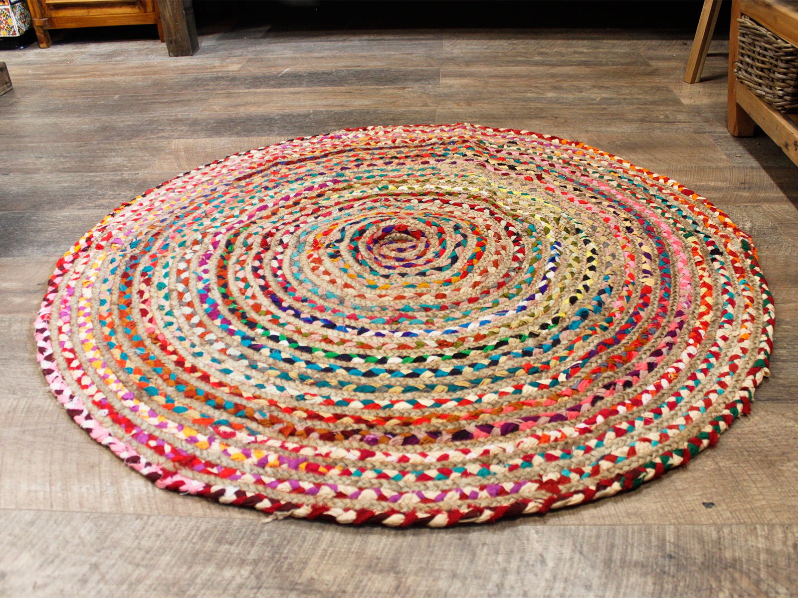 Colorful round braided area rug made of natural jute and cotton, featuring vibrant hues and a bohemian style.