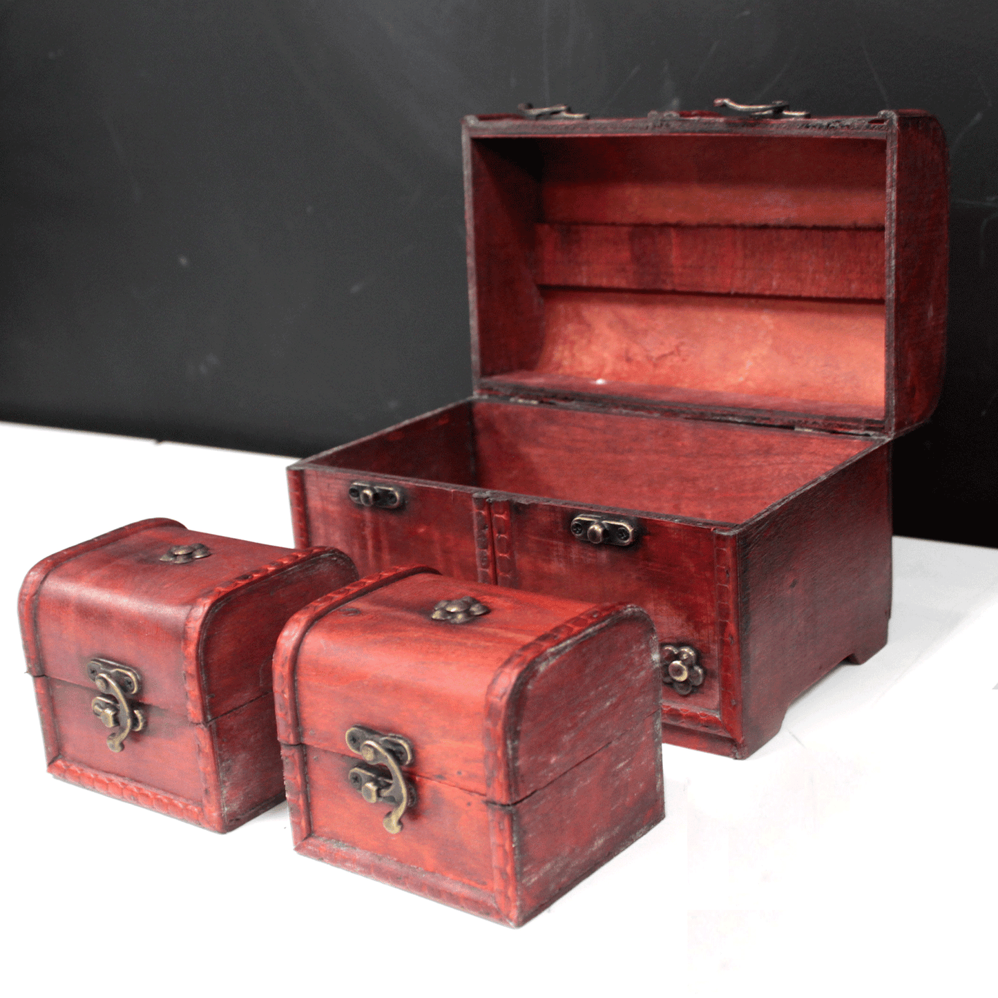 Caja de madera roja con cierres metálicos, incluye dos cajas pequeñas en estilo vintage. Ideal para almacenamiento decorativo.