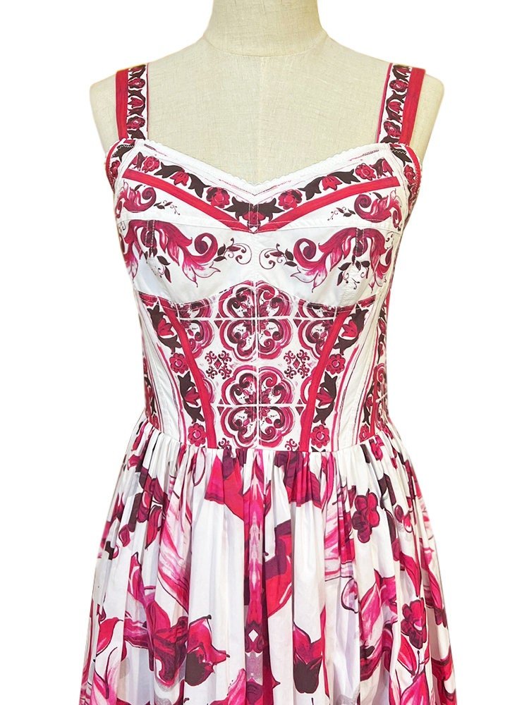 White and pink floral print dress with spaghetti straps and a fitted bodice, perfect for summer occasions.