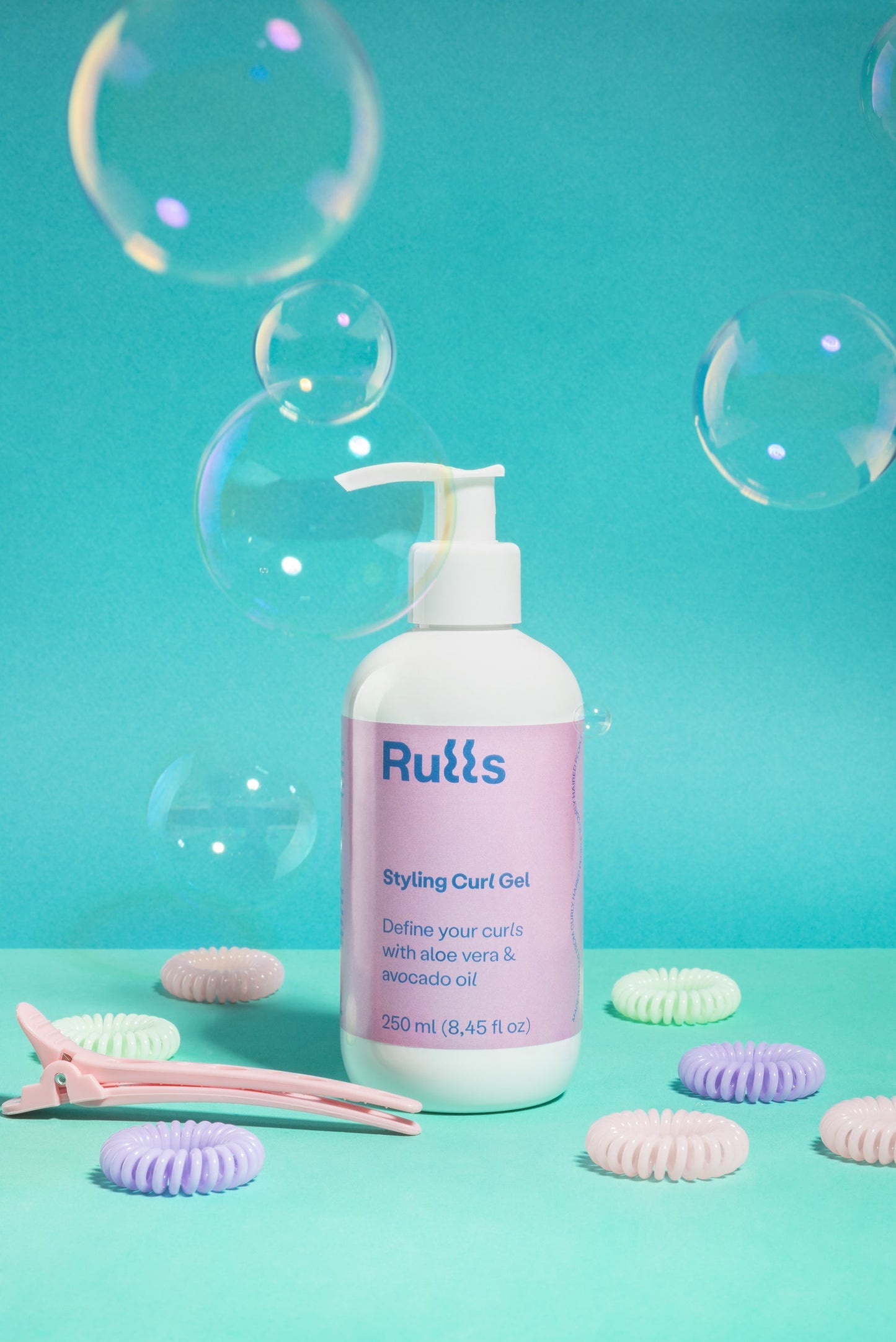 Gel para rizos Ruítss, 250 ml, con aloe vera y aceite de aguacate, envase blanco con etiqueta lila y fondo azul.