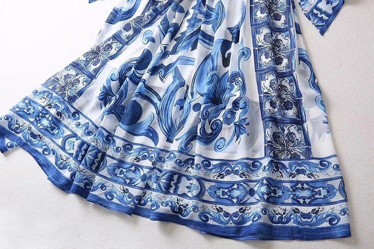 Blue floral print maxi dress, made of lightweight fabric, featuring intricate ceramic tile patterns and a flowing silhouette.