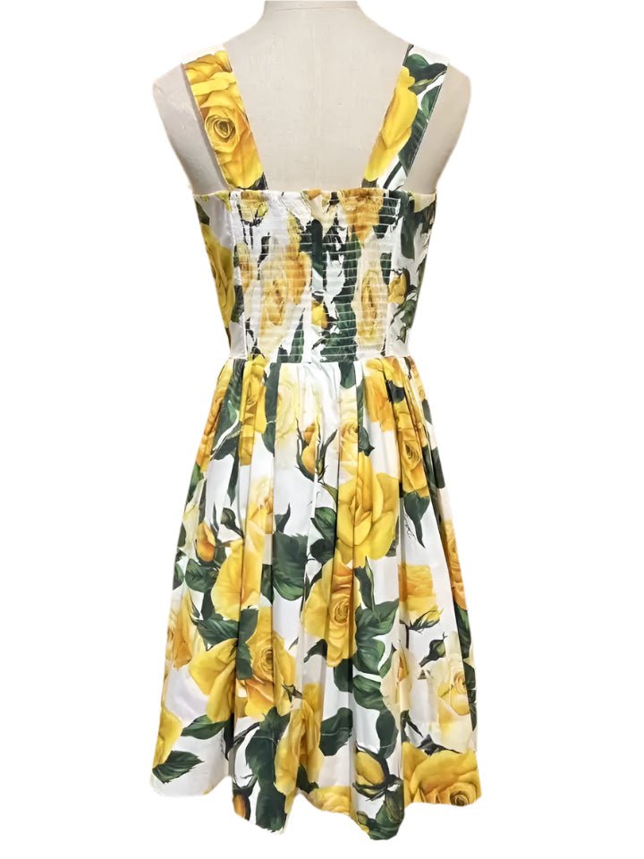 White sundress with yellow rose print, smocked back, and wide straps for a casual summer look.